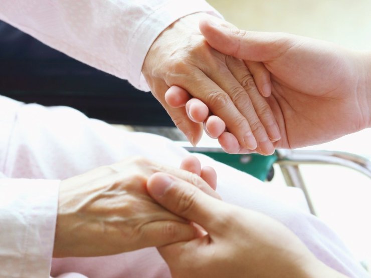 mani di una donna anziana in altre mani