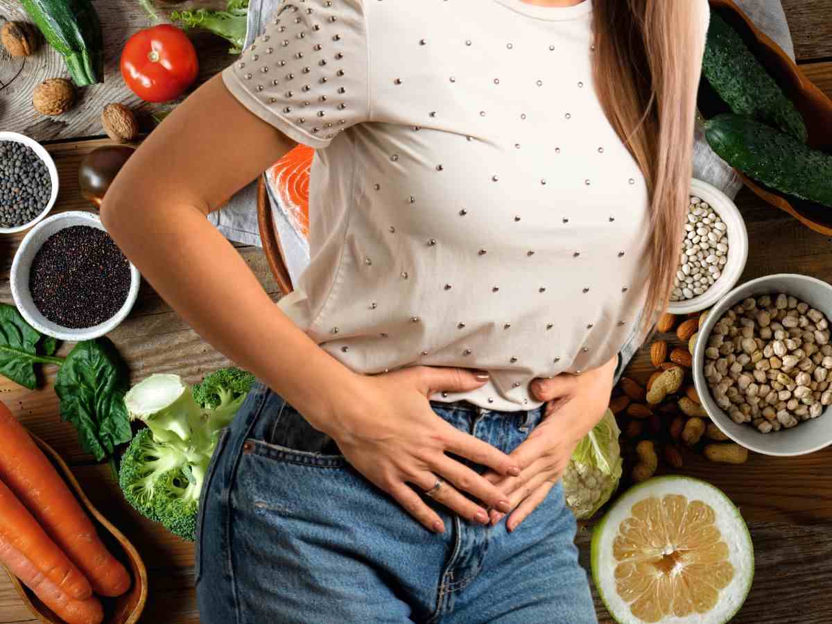 sfondo tavola con cibo e donna con mal di stomaco